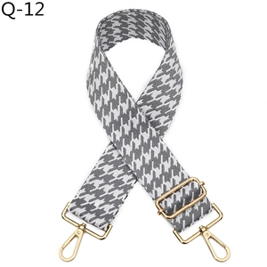 Close-up of thick jacquard houndstooth strap with polished gold hardware buckles