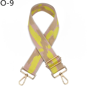 Detail view of adjustable wide canvas bag strap with colorful geometric pattern and gold clips