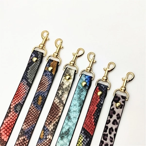 Detail of PU leather bag straps featuring snake and leopard prints with gold metal clasps