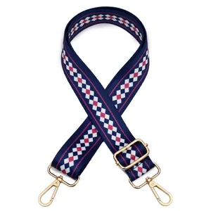 Close-up of adjustable navy blue geometric patterned woven bag strap with gold metal hooks