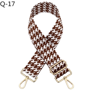Detail of jacquard houndstooth wide bag strap with golden rotating metal lobster hooks