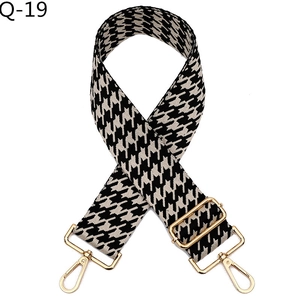Close-up of jacquard houndstooth bag strap with durable gold-tone metal lobster clasps