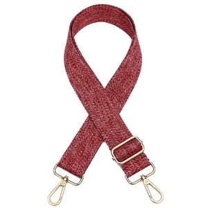 Détail de la bandoulière tissée rouge et blanche avec crochets dorés et boucle réglable
