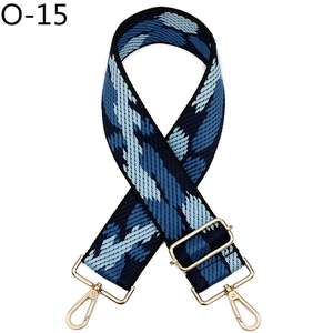 Detail of adjustable wide shoulder strap with blue geometric pattern and gold hardware