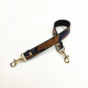 Detail of snake skin pattern handbag strap with premium golden lobster clasps