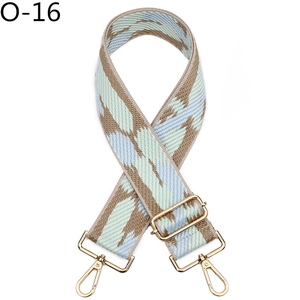 Detail of wide woven strap with blue and green geometric pattern and gold hardware