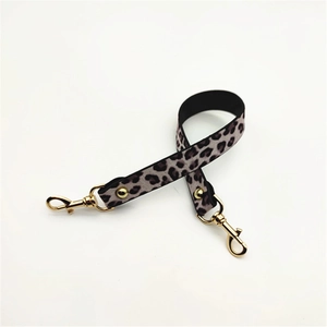 Detail shot of leopard print replacement bag strap with golden lobster clasps and rivets