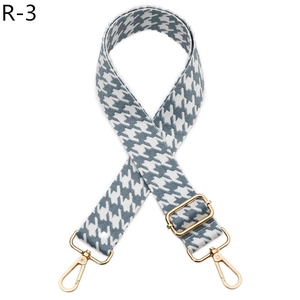 Detail of adjustable houndstooth shoulder strap with high-gloss gold metal hooks