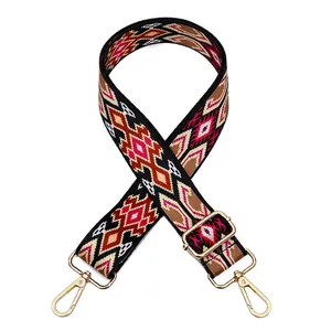 Detail of geometric pattern woven bag strap with golden rotating metal hooks