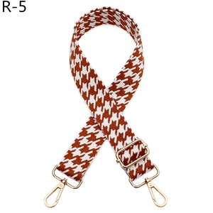Detail of adjustable houndstooth shoulder strap with gold metal buckles for handbags