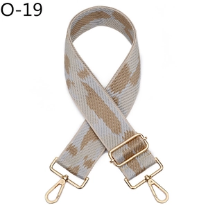 Close-up of adjustable woven bag strap with grey and khaki geometric pattern and gold hardware