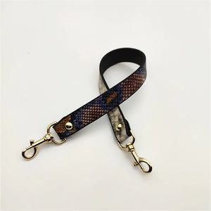 Close-up of PU leather shoulder strap featuring colorful snakeskin texture and gold lobster clasps