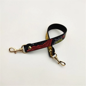 Close-up of snake print PU leather strap with gold rotating metal hooks for handbags