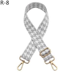 Detailed view of adjustable houndstooth bag strap with premium gold metal swivel hooks
