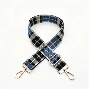 Close-up of adjustable blue and black checkered canvas strap with gold metal hooks