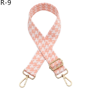 Detail of pink and white houndstooth jacquard strap with adjustable golden hardware