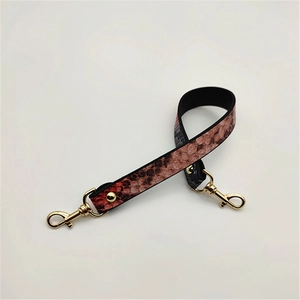 Detail of red-brown snakeskin pattern PU leather strap with golden lobster clasps