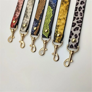 Detailed macro view of PU leather animal print bag straps with golden metal clasps