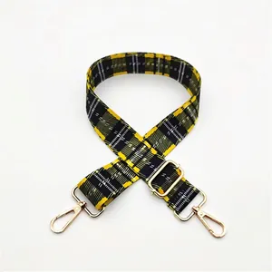 Detail view of yellow and black checkered adjustable shoulder strap with gold lobster clasps