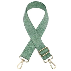 Détail de la bandoulière tissée vert et blanc avec boucle en métal doré