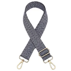 Détail d'une bandoulière tissée noir et blanc réglable avec boucle en métal doré chic