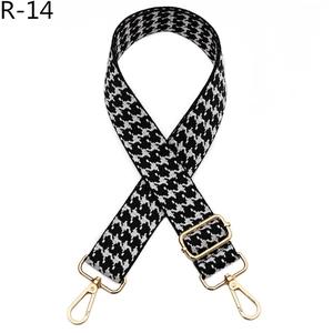 Detailed view of houndstooth jacquard strap with polished gold-tone metal lobster clasps