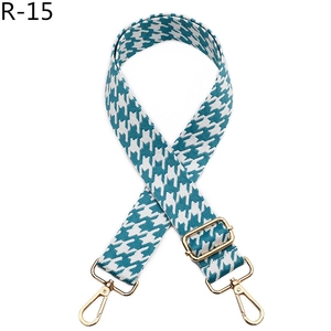 Detail of teal houndstooth jacquard bag strap with adjustable gold hardware buckles