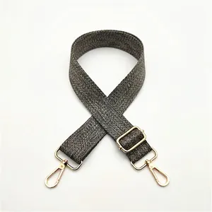 Détail de la bandoulière tissée gris et noir avec crochets et boucle en métal doré