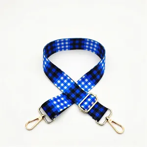 Close-up of blue and black checkered bag strap with adjustable gold zinc alloy buckle