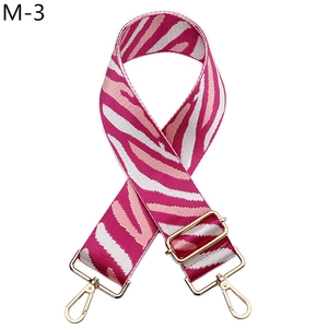 Detail of zebra pattern canvas bag strap with golden metal snap hooks and adjuster
