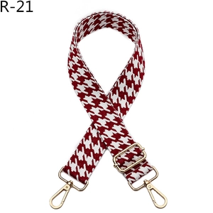 Detail of red and white houndstooth bag strap with adjustable gold lobster clasps