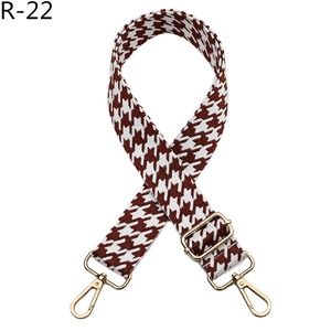 Detail of houndstooth jacquard shoulder strap with gold-tone adjustable metal buckle