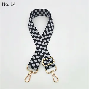 Detail of adjustable black and white checkered shoulder strap with gold metal hooks
