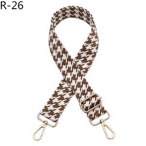 Detail view of woven houndstooth bag strap with adjustable gold alloy buckle and hook