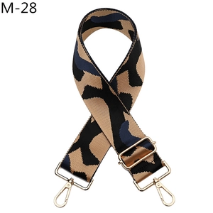 Detail of adjustable wide camouflage strap with gold metal hooks for handbags