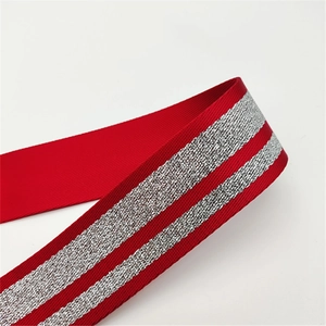 Dettaglio tracolla rossa con strisce parallele in argento metallizzato e glitterato
