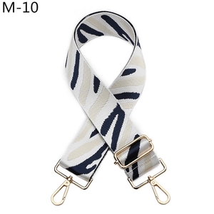 Detail of adjustable woven strap with navy zebra pattern and gold metal buckles