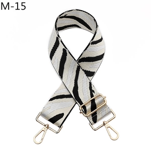 Close-up of zebra pattern woven bag strap with golden rotating lobster buckles