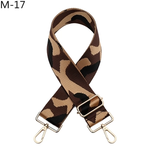 Detail of adjustable camouflage canvas strap with polished gold metal swivel hooks