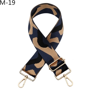 Detail of adjustable wide canvas shoulder strap with geometric pattern and gold clasps