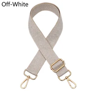 Adjustable cream bag strap with golden rotating clasps and herringbone woven texture