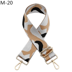 Close-up of adjustable jacquard bag strap with geometric patterns and golden metal clasps