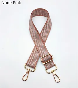 Close-up of adjustable pink and grey herringbone strap with polished gold-tone metal hooks