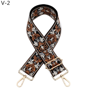 Dettaglio della tracolla jacquard stile etnico con motivi floreali e ganci in metallo oro