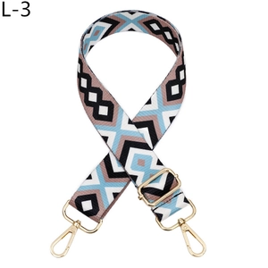 Close-up of geometric jacquard bag strap with gold metal hooks and adjustable buckle