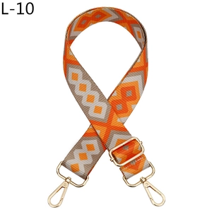 Close-up of geometric diamond pattern shoulder strap with gold-tone metal hardware clips