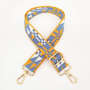 Close-up of colorful ethnic style bag strap with yellow geometric patterns and gold clips