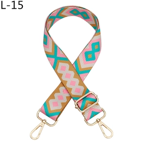 Detail of colorful geometric woven bag strap with ethnic diamond pattern and gold metal hooks