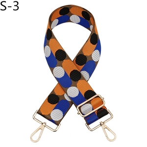 Close-up of adjustable jacquard bag strap with colorful polka dots and gold metal hooks