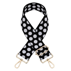 Close-up of black and white polka dot jacquard woven bag strap with gold metal hooks